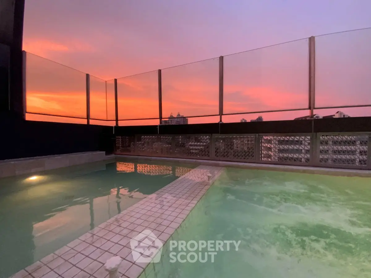 Stunning rooftop pool with sunset view in urban setting