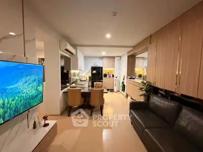Modern open-layout living room with sleek kitchen and cozy seating area, perfect for urban living.