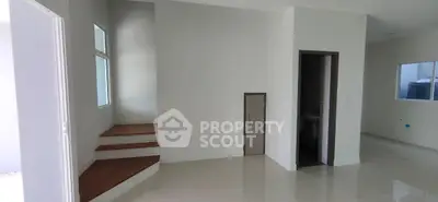 Spacious modern interior with sleek staircase and glossy tiled floors, perfect for contemporary living.