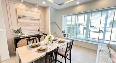 Elegant dining area with large windows and modern decor in a stylish home.