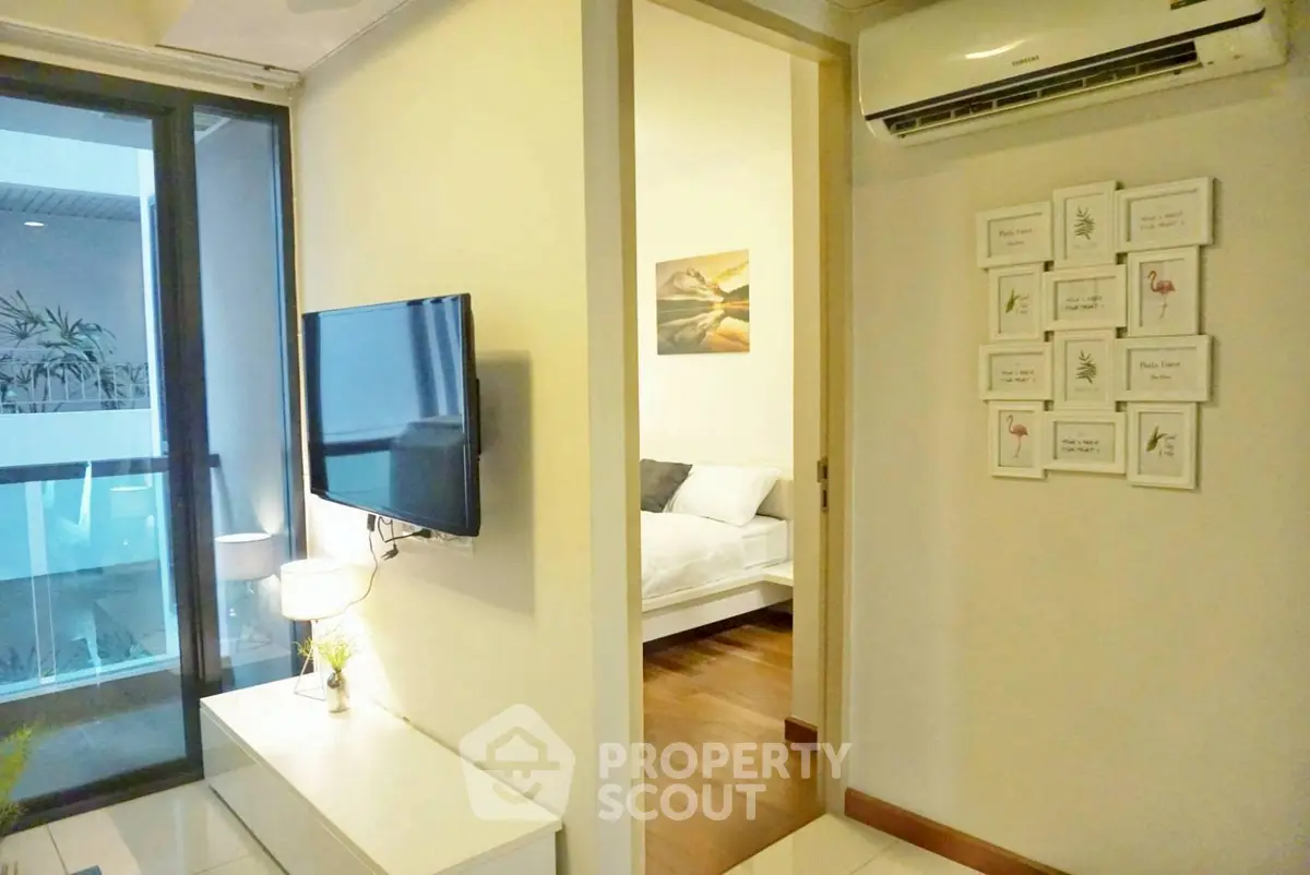 Modern apartment interior with TV, air conditioning, and balcony view