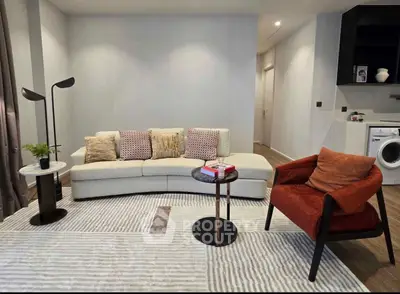 Modern living room with stylish furniture and washing machine in open layout