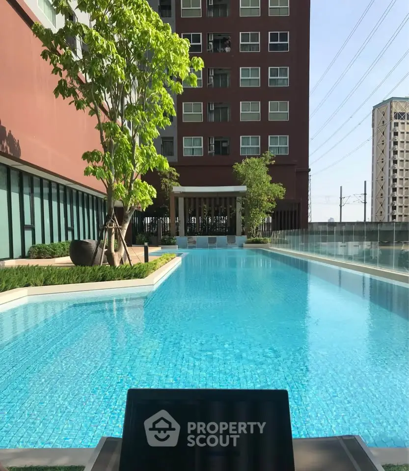 Luxurious apartment building with stunning pool and lush greenery, perfect for relaxation and leisure.