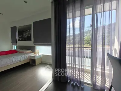 Bright bedroom with large windows and scenic view, featuring modern decor and cozy ambiance.