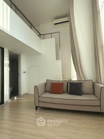 Modern loft apartment with high ceilings and stylish sofa