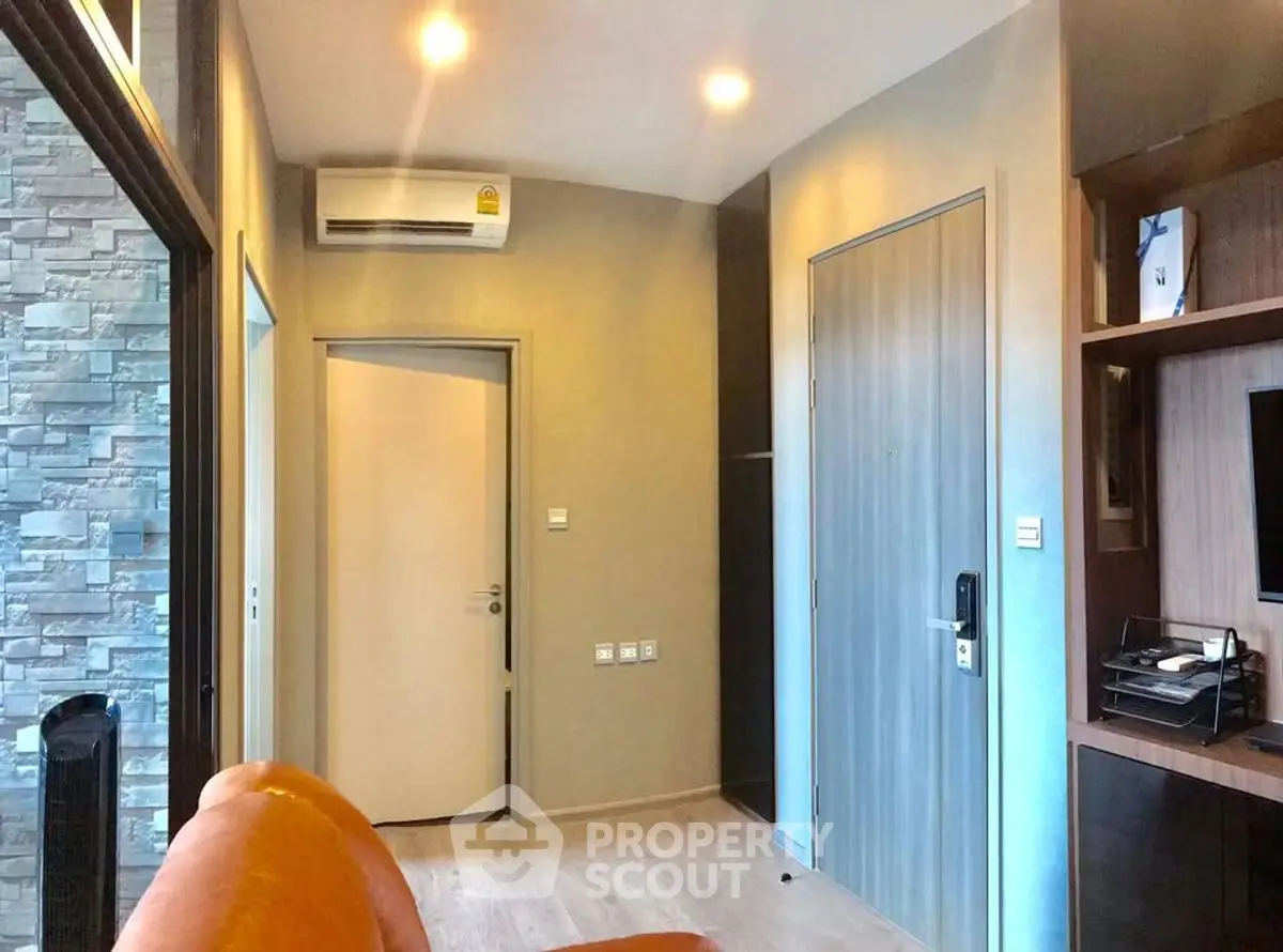 Modern living room with sleek design and air conditioning, featuring a cozy orange sofa and stylish wooden accents.