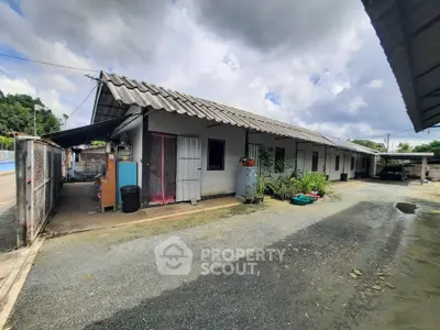 Charming single-story building with rustic roof and spacious outdoor area.