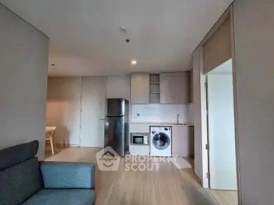Modern apartment interior with kitchen and living area featuring sleek appliances and minimalist design.