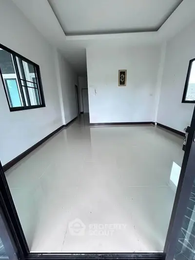 Spacious empty room with glossy tiled floor and modern design, perfect for customization.