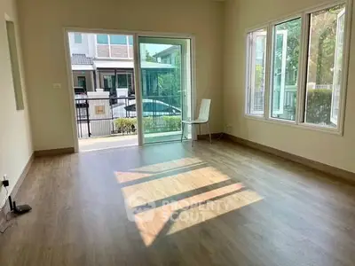 Spacious empty room with large windows and sliding glass door, perfect for customization.