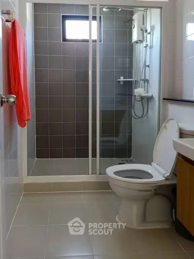 Modern bathroom with glass shower and sleek fixtures in a contemporary home.