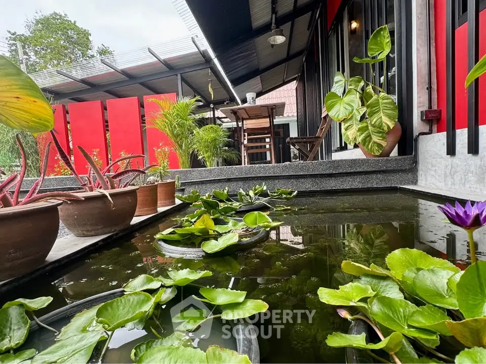 Charming garden view with lush greenery and serene pond in modern outdoor space.