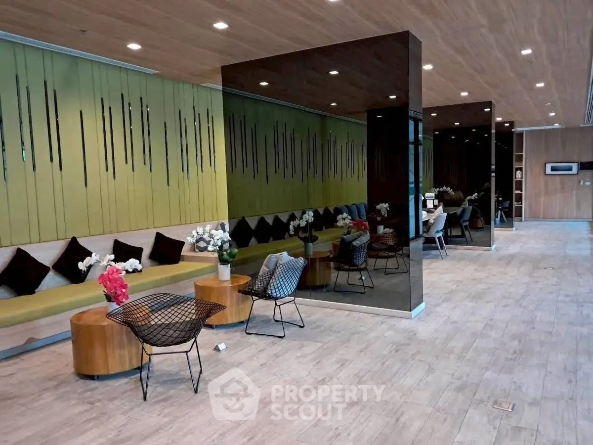Modern lobby with stylish seating and decorative mirrors in a contemporary building.