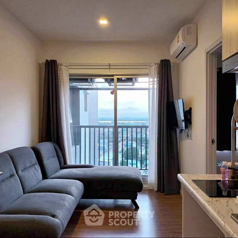 Modern living room with balcony and stunning view, featuring sleek furniture and contemporary design.