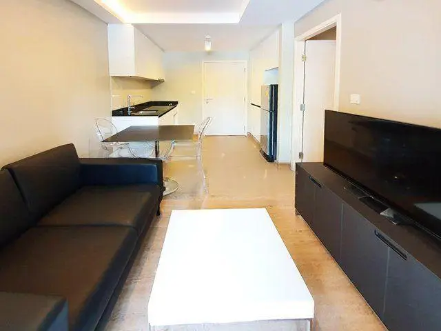 Modern open-layout living room with sleek furniture and integrated kitchen area.