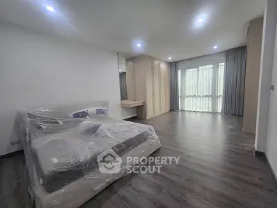 Spacious bedroom with modern design and large windows for natural light.