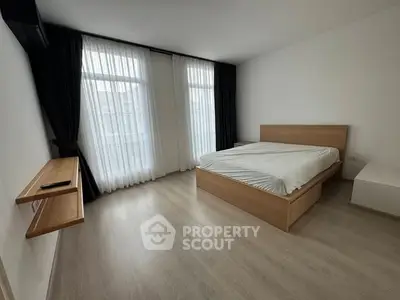 Spacious modern bedroom with large windows and minimalist design