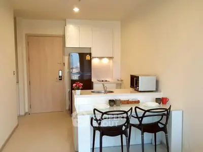 Modern kitchen with sleek design, featuring white cabinetry, stainless steel appliances, and cozy dining area.