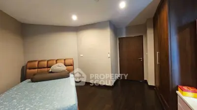 Cozy bedroom with modern design and wooden flooring, featuring a comfortable bed and ample closet space.