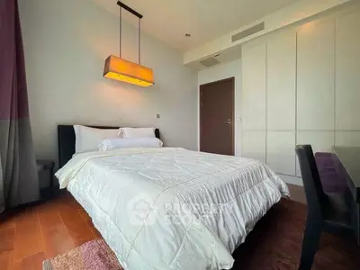 Modern bedroom with cozy bed, stylish lighting, and ample storage in a contemporary apartment.