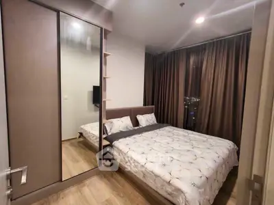 Modern bedroom with stylish decor and large mirrored wardrobe