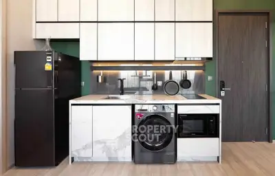 Modern kitchen with sleek appliances and stylish cabinetry in a contemporary apartment.