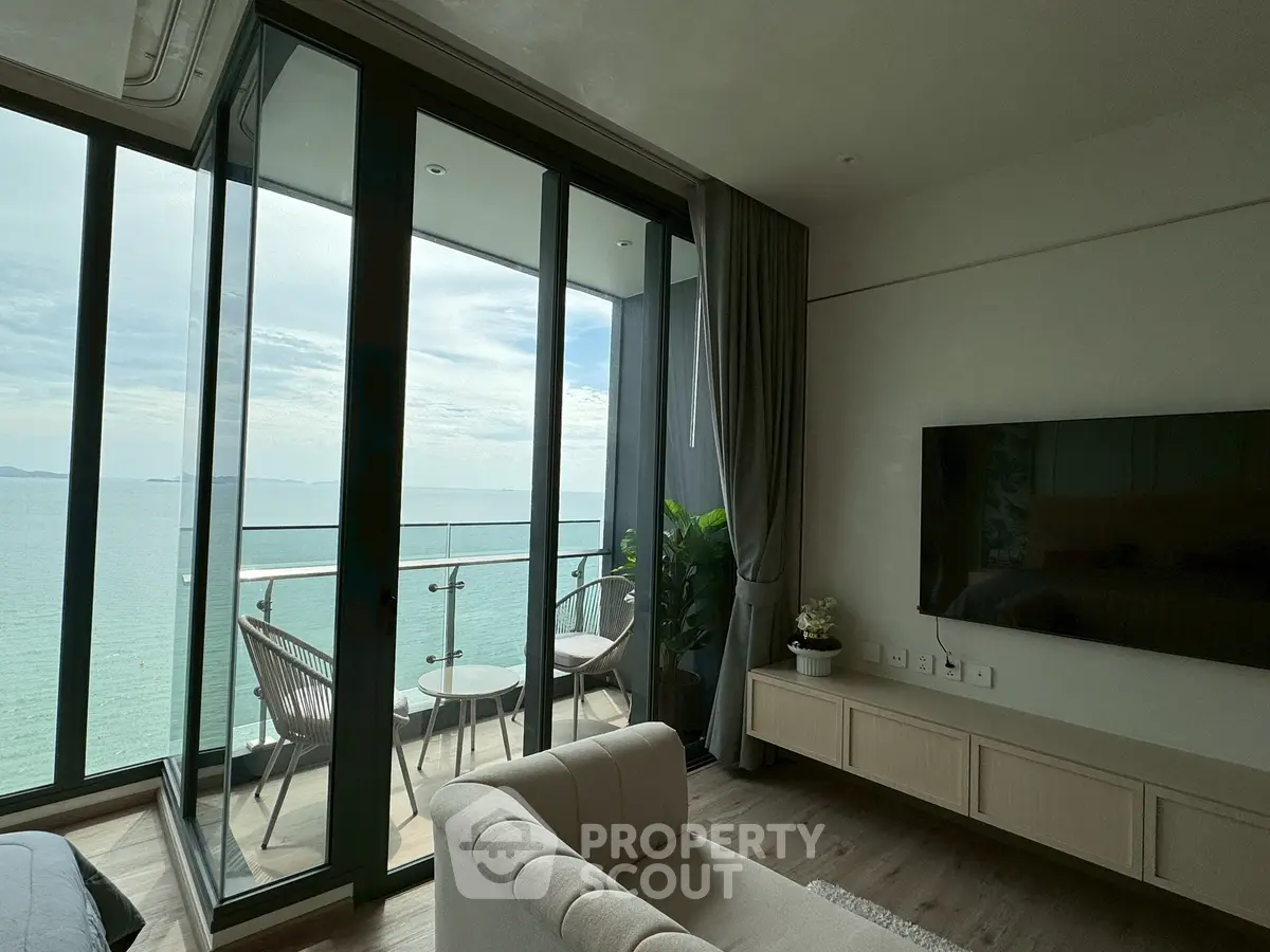 Luxurious living room with stunning ocean view and modern balcony seating.