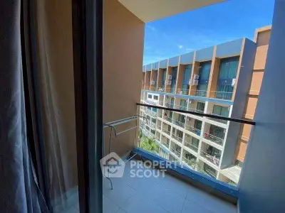 Modern apartment balcony with stunning city view and sleek glass railing.