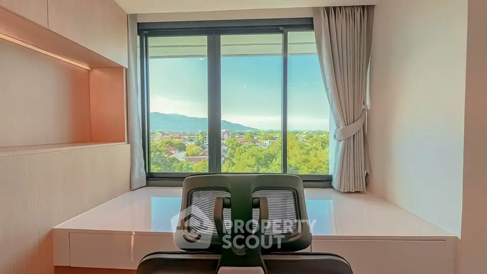 Modern study room with panoramic window view of lush greenery and mountains, featuring sleek desk and chair.