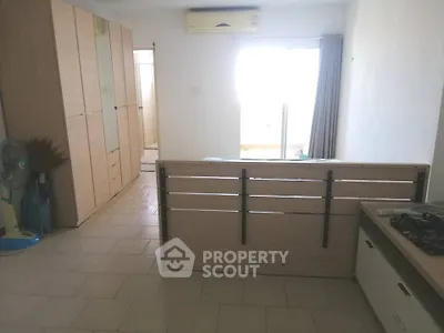 Spacious room with modern furniture and natural light from large window.