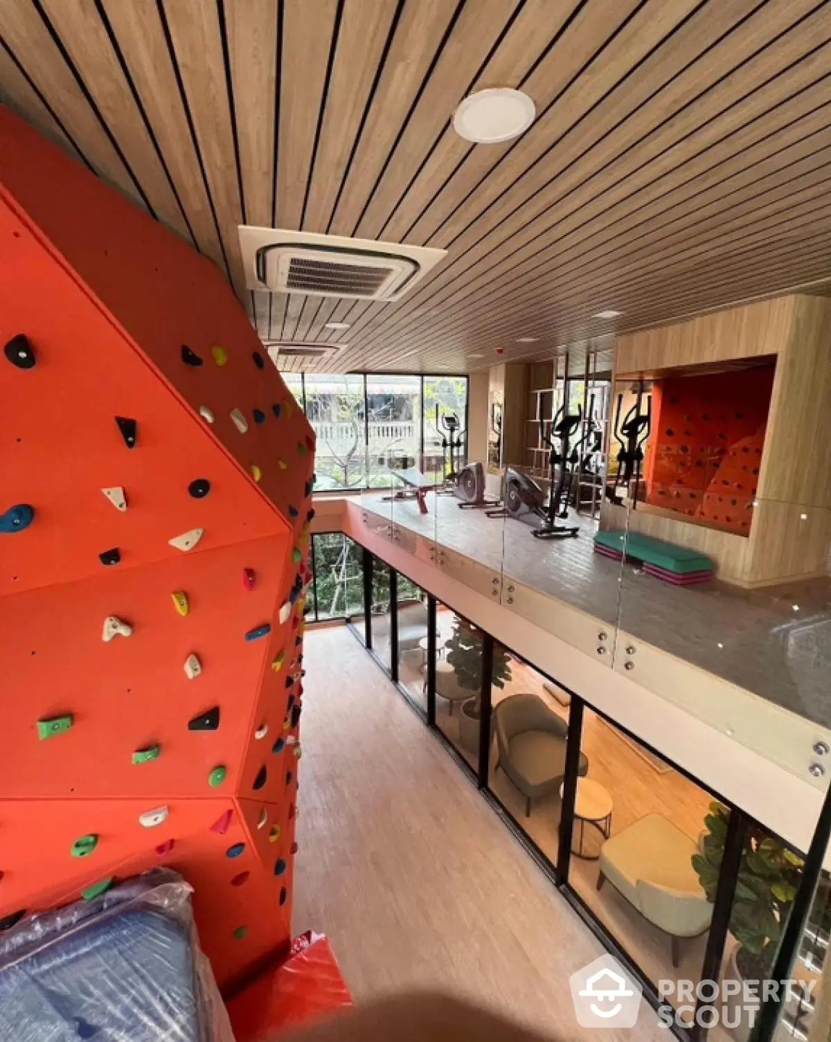 Modern gym with climbing wall and exercise equipment in luxury apartment complex