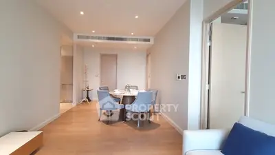 Spacious modern living room with elegant dining area and wooden flooring.