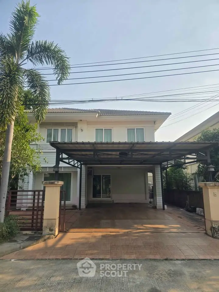 Charming two-story house with spacious driveway and lush greenery, perfect for family living.