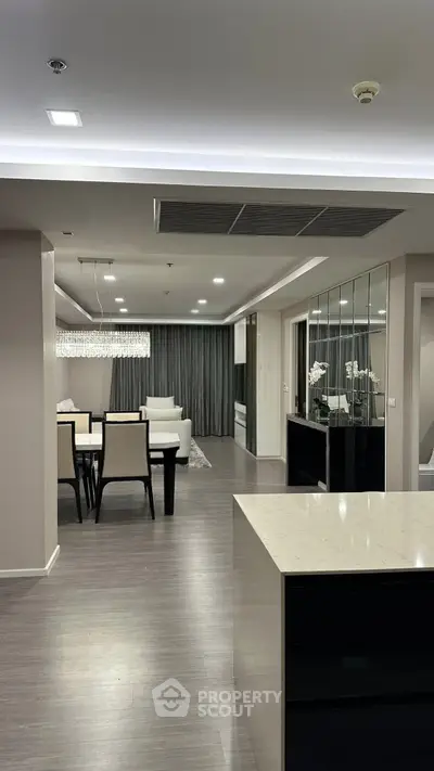 Luxurious open-plan living and dining area with modern decor and elegant lighting.