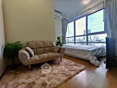 Modern bedroom with cozy sofa and large window offering stunning city views