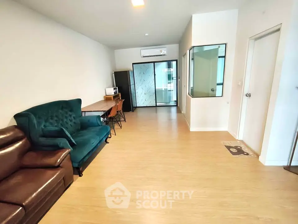 Spacious living room with modern furniture and wooden flooring in a stylish apartment.