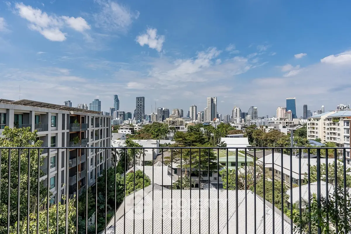 Stunning cityscape view from a modern balcony overlooking urban skyline and lush greenery.
