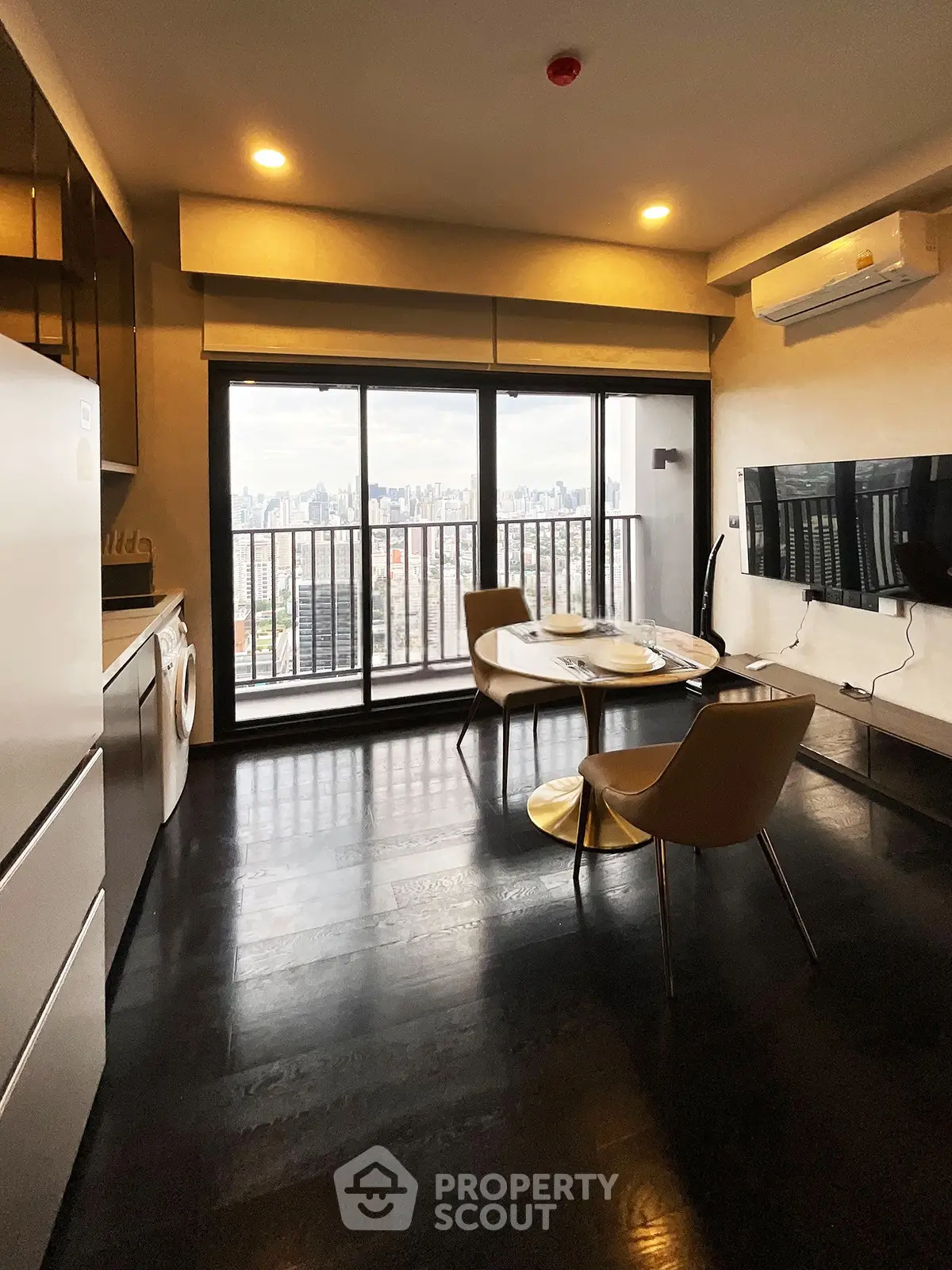 Modern living room with city view, sleek furniture, and large windows in urban apartment.