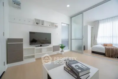 Modern living room with sliding doors leading to a cozy bedroom, featuring stylish decor and natural light.