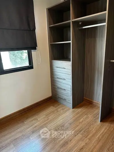 Spacious bedroom with elegant wooden flooring and built-in closet, perfect for modern living.