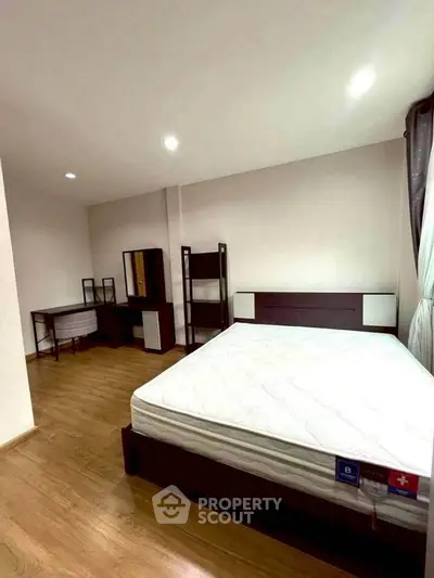 Spacious bedroom with modern furniture and natural light