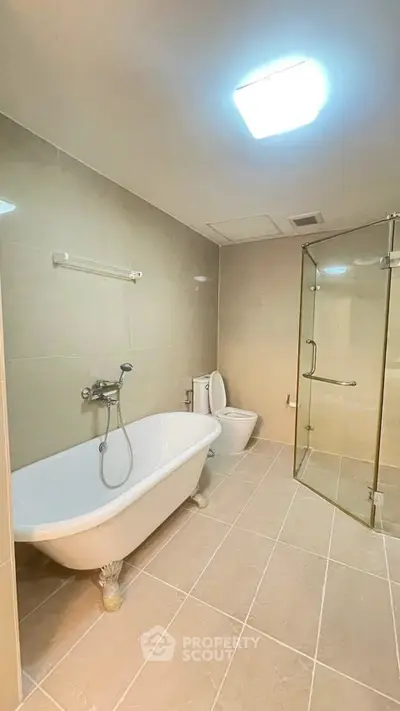 Spacious bathroom with elegant bathtub and modern shower enclosure.
