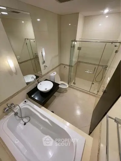 Luxurious bathroom with modern fixtures, glass shower, and elegant bathtub in a high-end property.