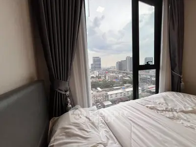 Luxurious bedroom with stunning city view from large window, featuring elegant curtains and cozy bedding.