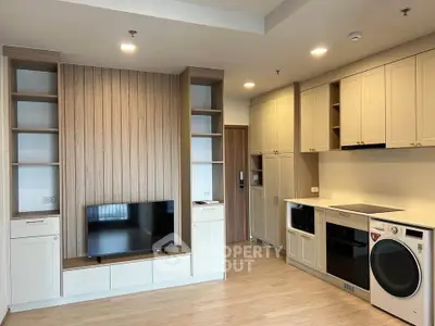 Modern living room with built-in entertainment center and kitchen appliances
