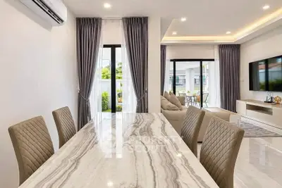 Modern open-plan living and dining area with elegant marble table and stylish decor.