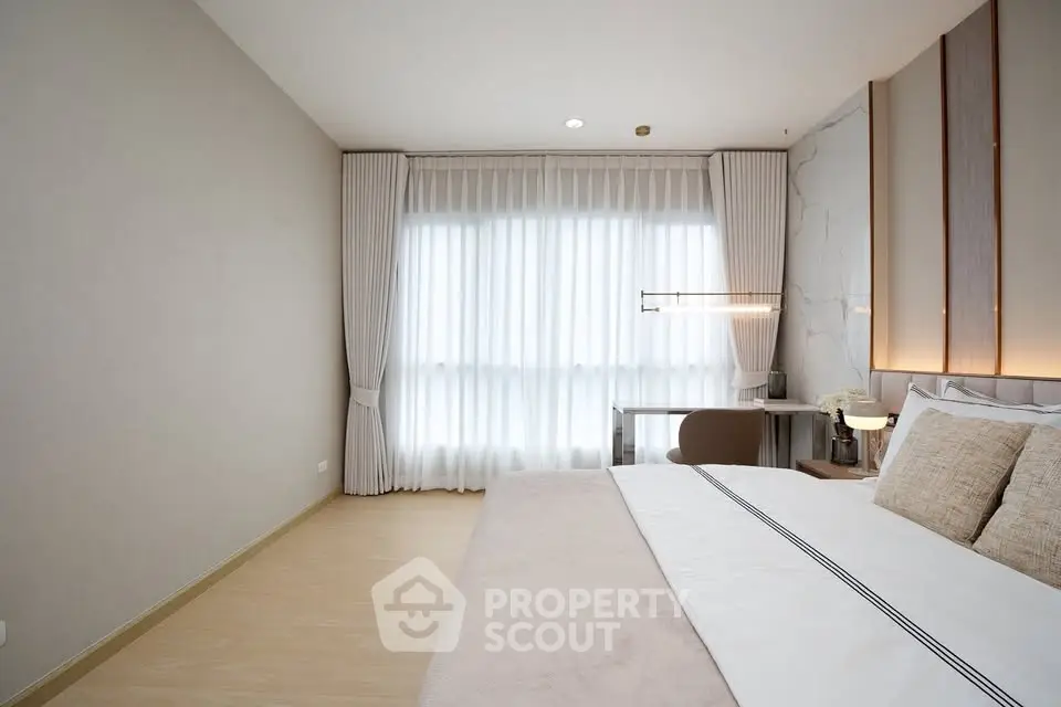Elegant bedroom with modern decor and natural light, featuring a cozy bed and stylish curtains.