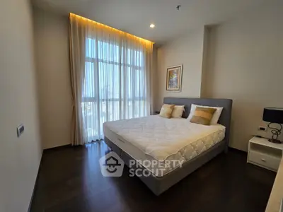 Spacious bedroom with large window and elegant decor in modern apartment