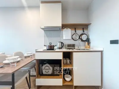 Modern compact kitchen with open shelving and dining area, featuring sleek appliances and minimalist design.