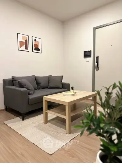Cozy living room with modern gray sofa, wooden coffee table, and stylish wall art.